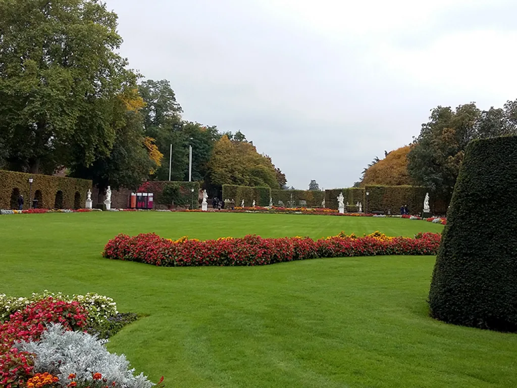 Palastgarten mit Blumenbeeten und Hecken.